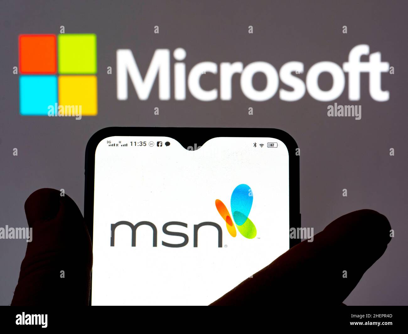Dans cette illustration, le logo MSN (Microsoft News) s'affiche sur un smartphone et le logo Microsoft en arrière-plan. Banque D'Images