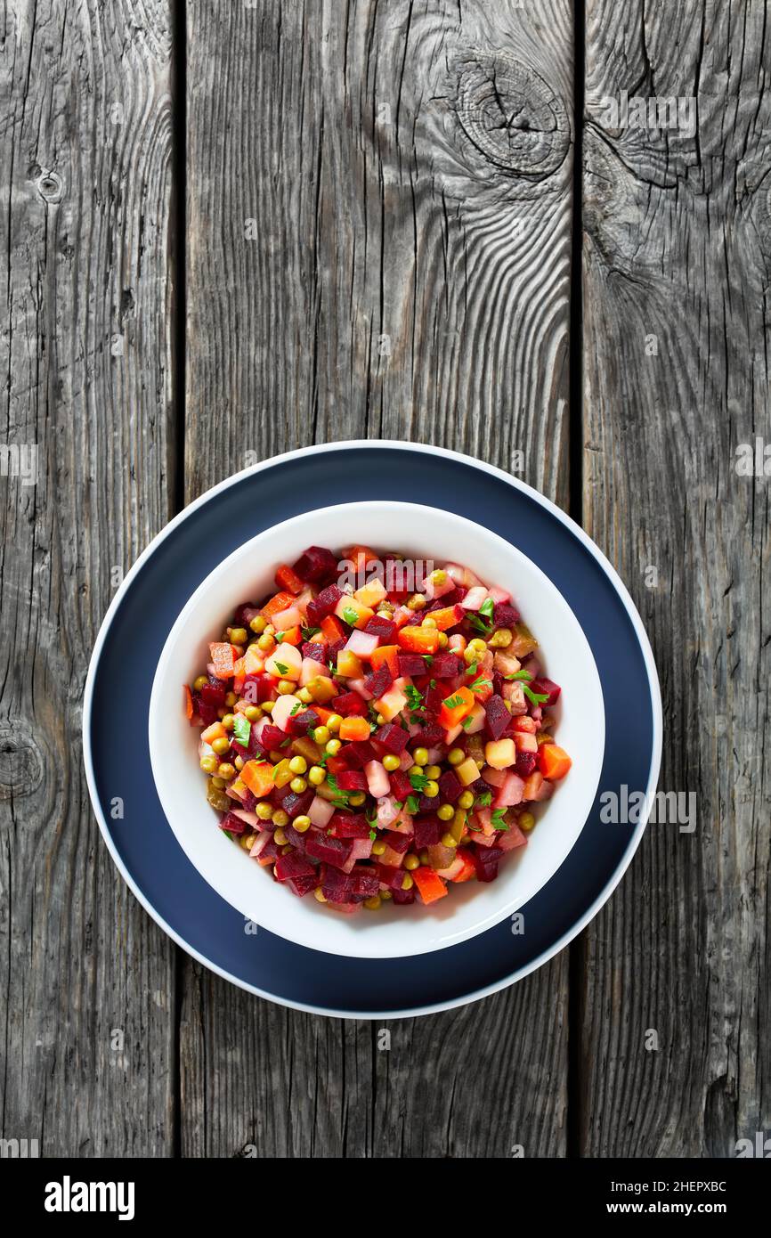 Vinegret, vinaigrette russe, salade de betteraves rouges cuites en dés, pommes de terre, carottes, oignons hachés, cornichons sautés,petits pois verts dans un bol Banque D'Images