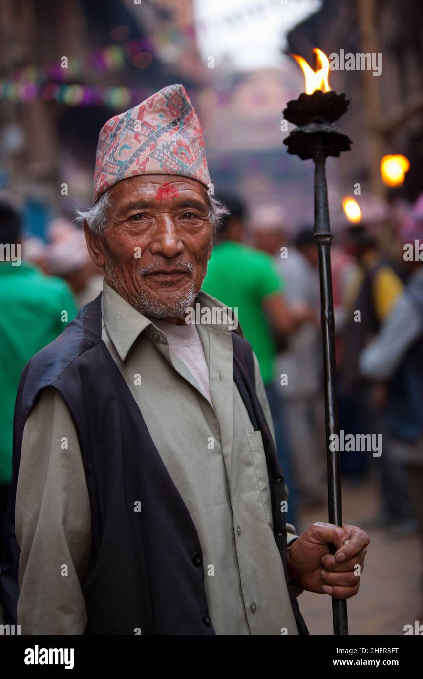 Un porteur de flambeau pendant Brahmayani Jatra sur la place Dattatreya de Bhaktapur pendant les festivités du nouvel an népalais. Banque D'Images