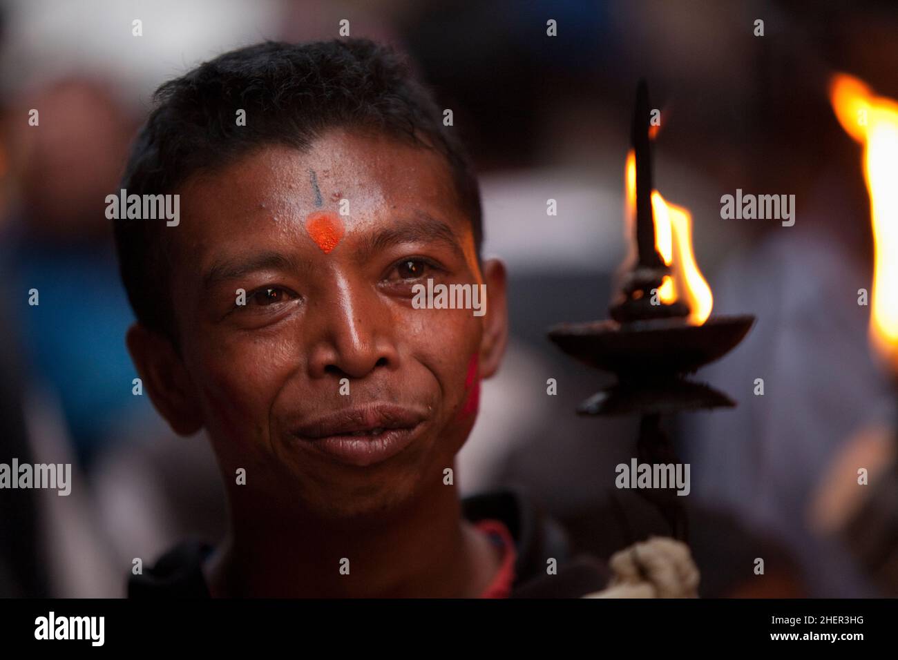 Un porteur de flambeau pendant Brahmayani Jatra sur la place Dattatreya de Bhaktapur pendant les festivités du nouvel an népalais. Banque D'Images