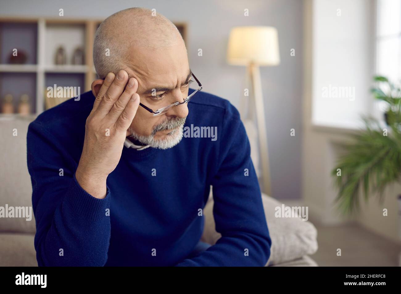 Un homme plus âgé avec une expression sérieuse et réfléchie ne pense pas à quelque chose d'important. Banque D'Images