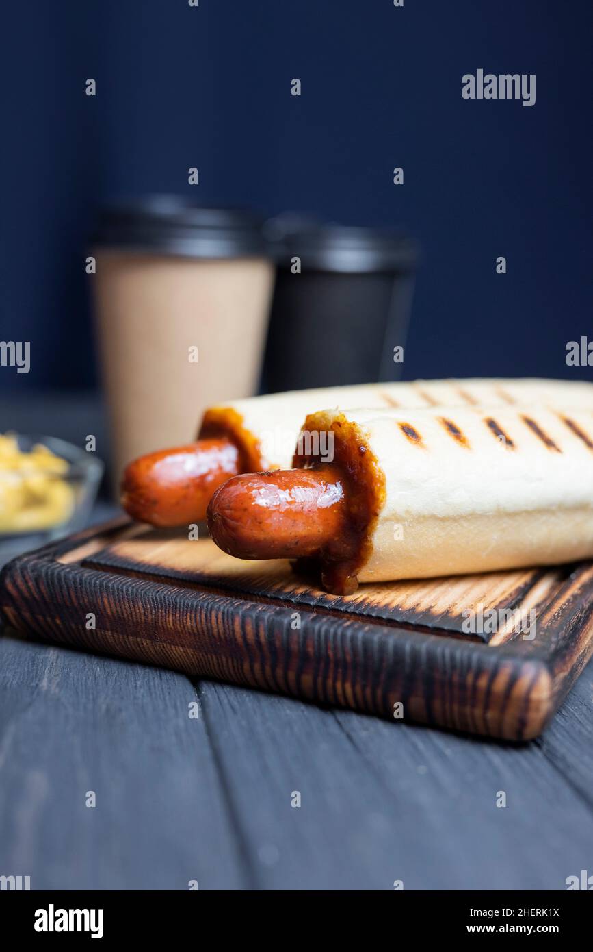 chien chaud français en rouleau avec sauce ketchup et une boisson au café dans un verre Banque D'Images