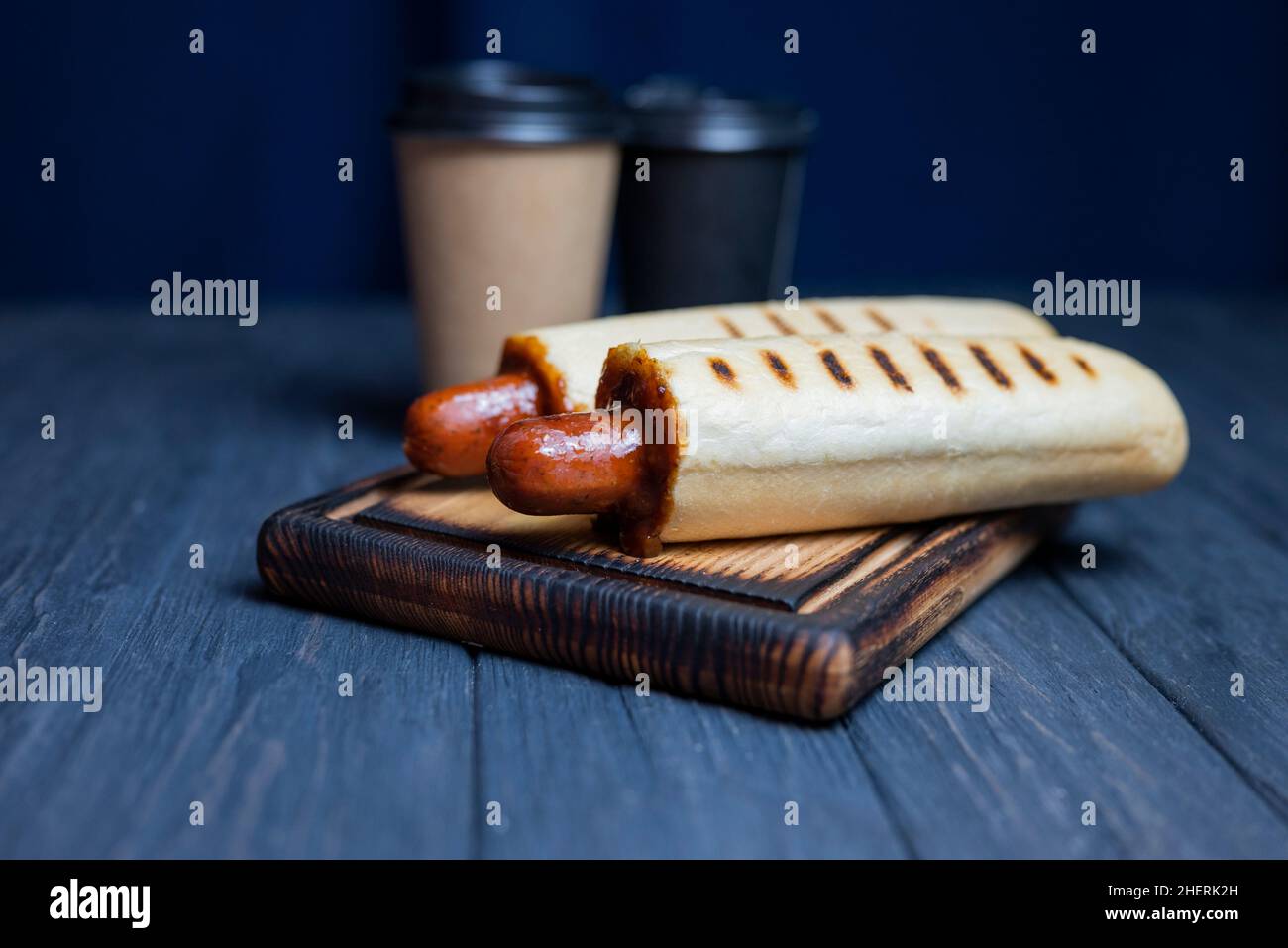 chien chaud français en rouleau avec sauce ketchup et une boisson au café dans un verre Banque D'Images