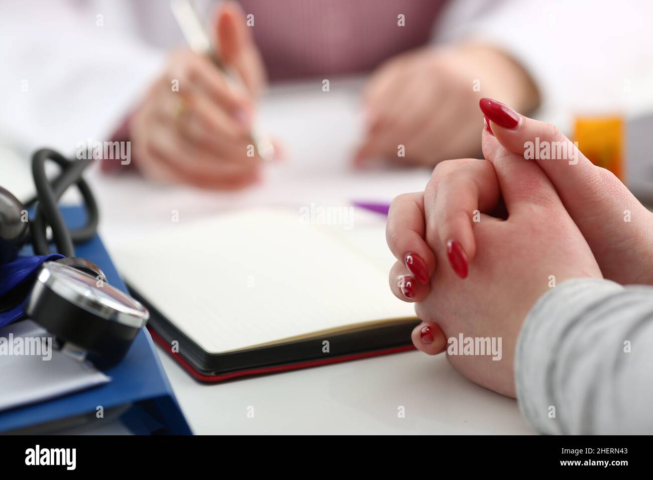 Mains de la patiente pour rapport médical écrit par le médecin état de santé Banque D'Images