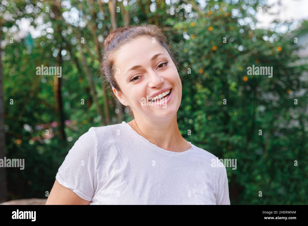 Jeune femme souriante à l'extérieur.Belle petite fille brunete reposant sur un parc ou un jardin vert.Femme heureuse gratuite en été.Liberté bonheur sans souci Happy People concept Banque D'Images