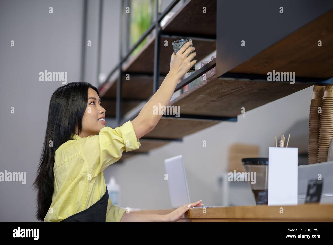 Une jeune femme asiatique écrit un menu à bord dans un café Banque D'Images