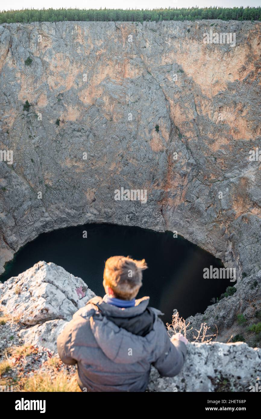 Homme blond se détendant au lac rouge en avril à Imotski, Dalmatie, Croatie Banque D'Images
