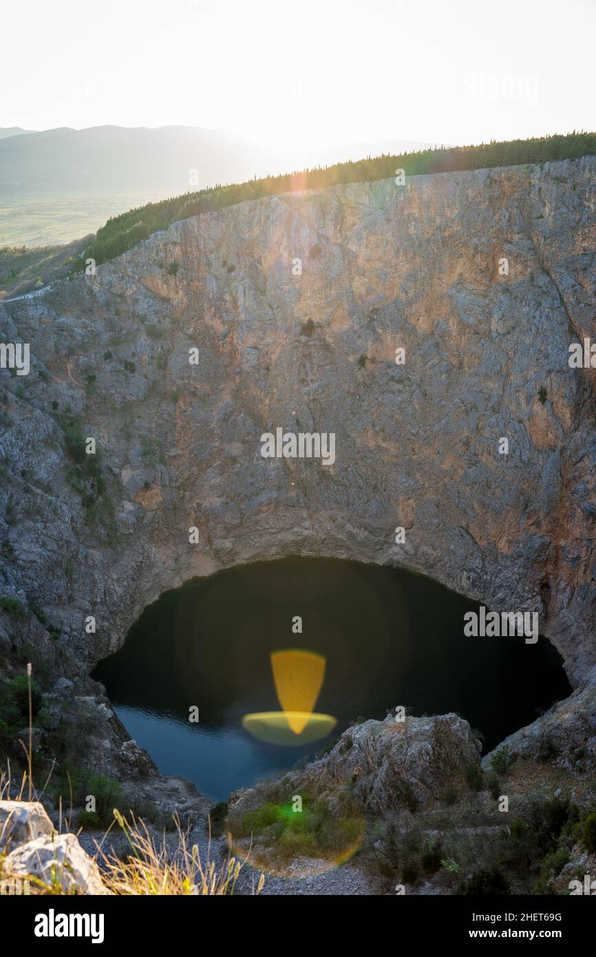 Le soleil se dirige vers la caméra du lac rouge en avril à Imotski, Dalmatie, Croatie Banque D'Images