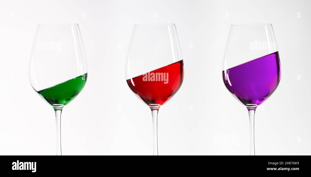 trois verres à vin vert rouge et violet inclinés Banque D'Images