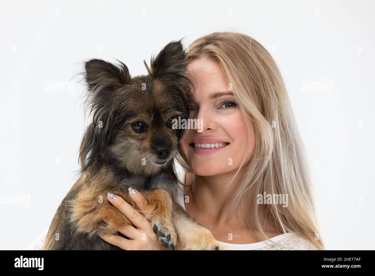 Une jeune fille embrasse son chien qu'elle tient dans ses bras.Portrait d'une femme et d'un chien.Chien de race multiple. Banque D'Images