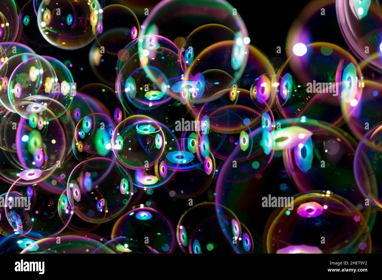 couleurs arc-en-ciel de bulles de savon volantes sur fond noir Banque D'Images