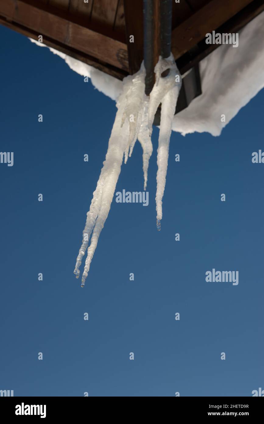 glace froide sur toit en bois avec neige et ciel bleu en hiver Banque D'Images