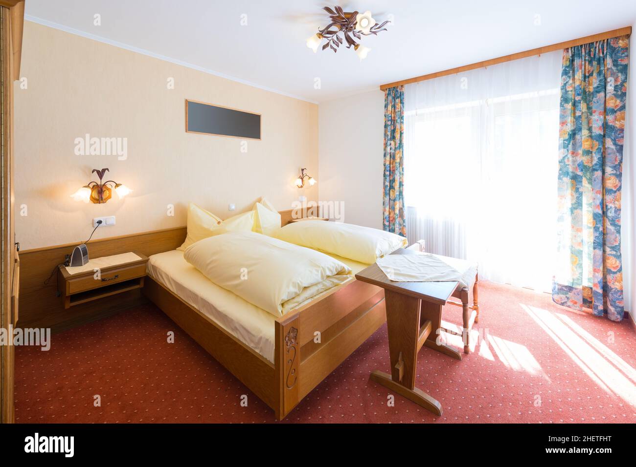 chambre rurale en bois avec une immense fenêtre, des rideaux et de la moquette Banque D'Images