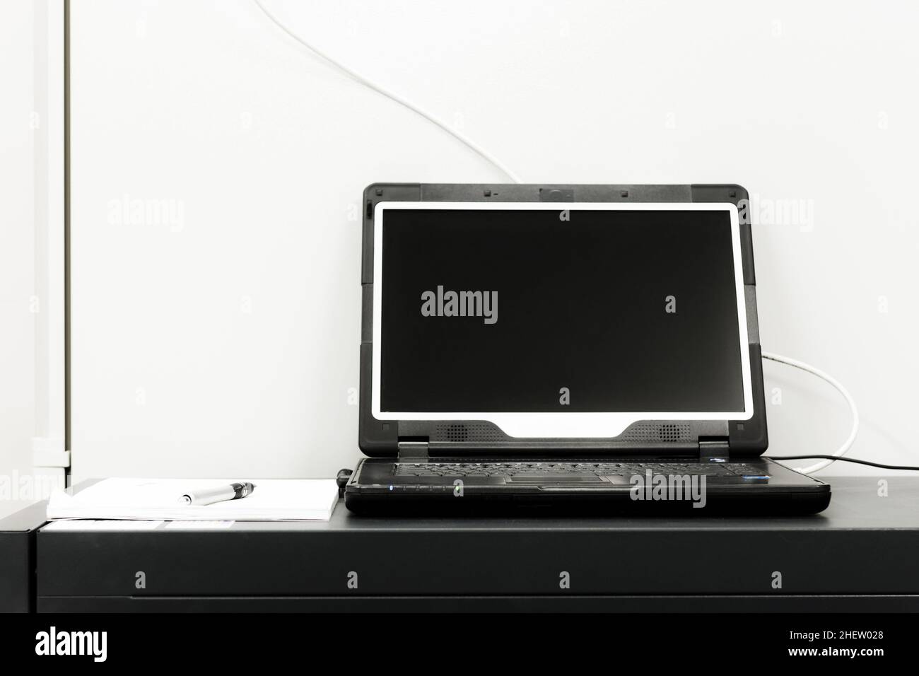 ordinateur portable noir avec écran ouvert devant le rack de serveurs Banque D'Images