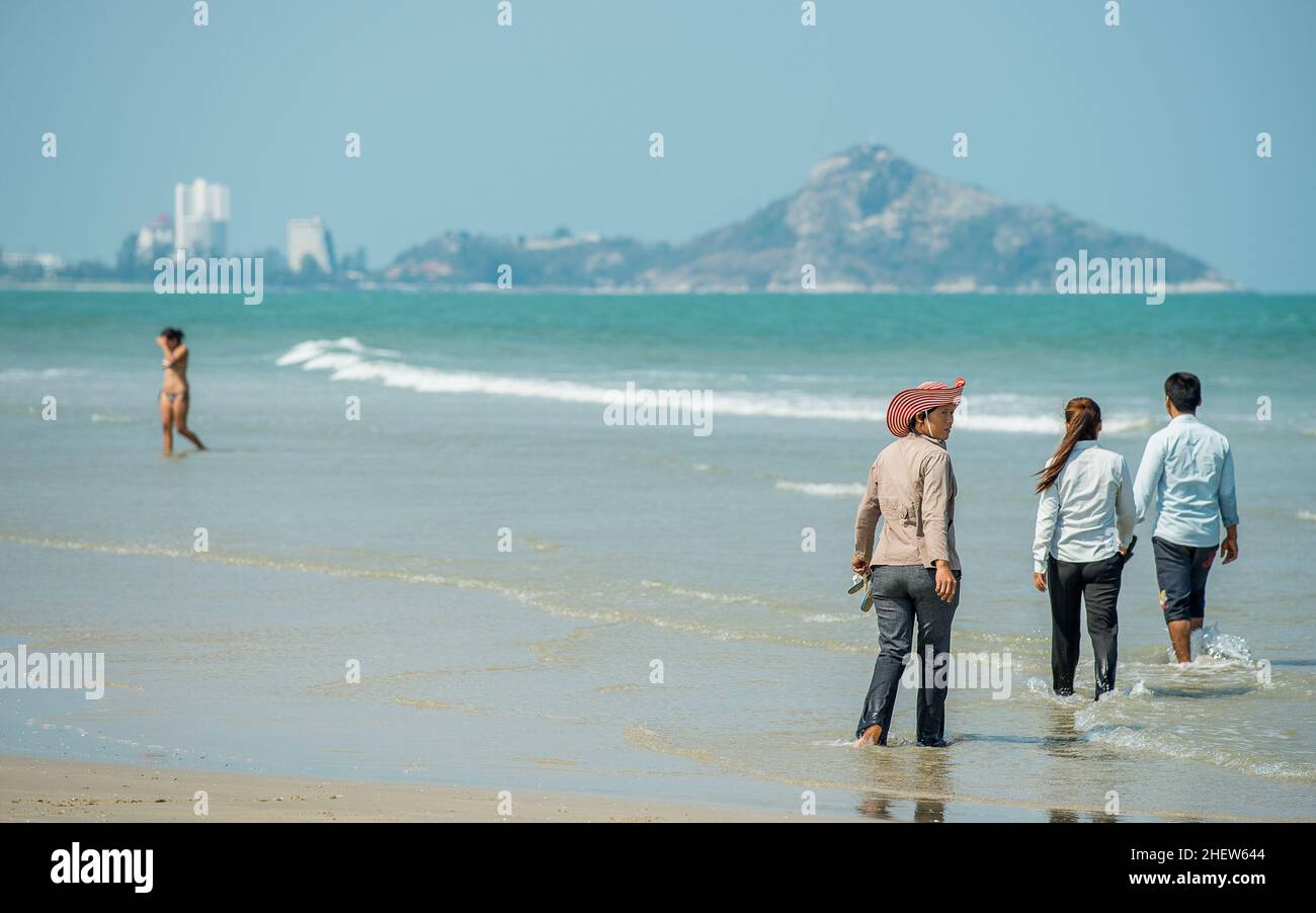 Les gens marchent dans la mer à Khao Tao Beach à Khao Tao au sud de Hua Hin, province de Prachuap Khiri Khan, Thaïlande Banque D'Images