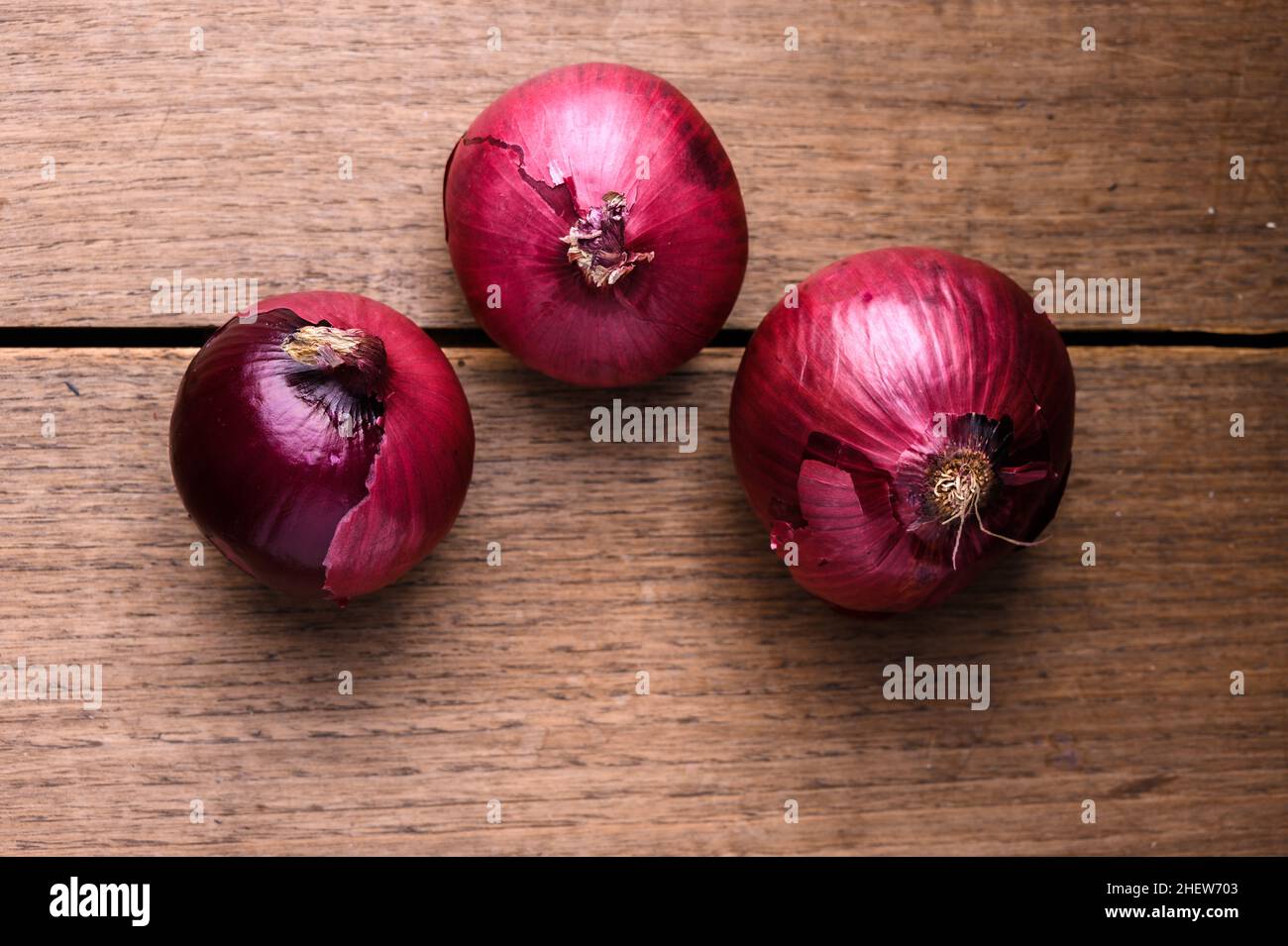 Des oignons fraîchement récoltés de différents types et tailles sur une table en bois.Photo de haute qualité Banque D'Images