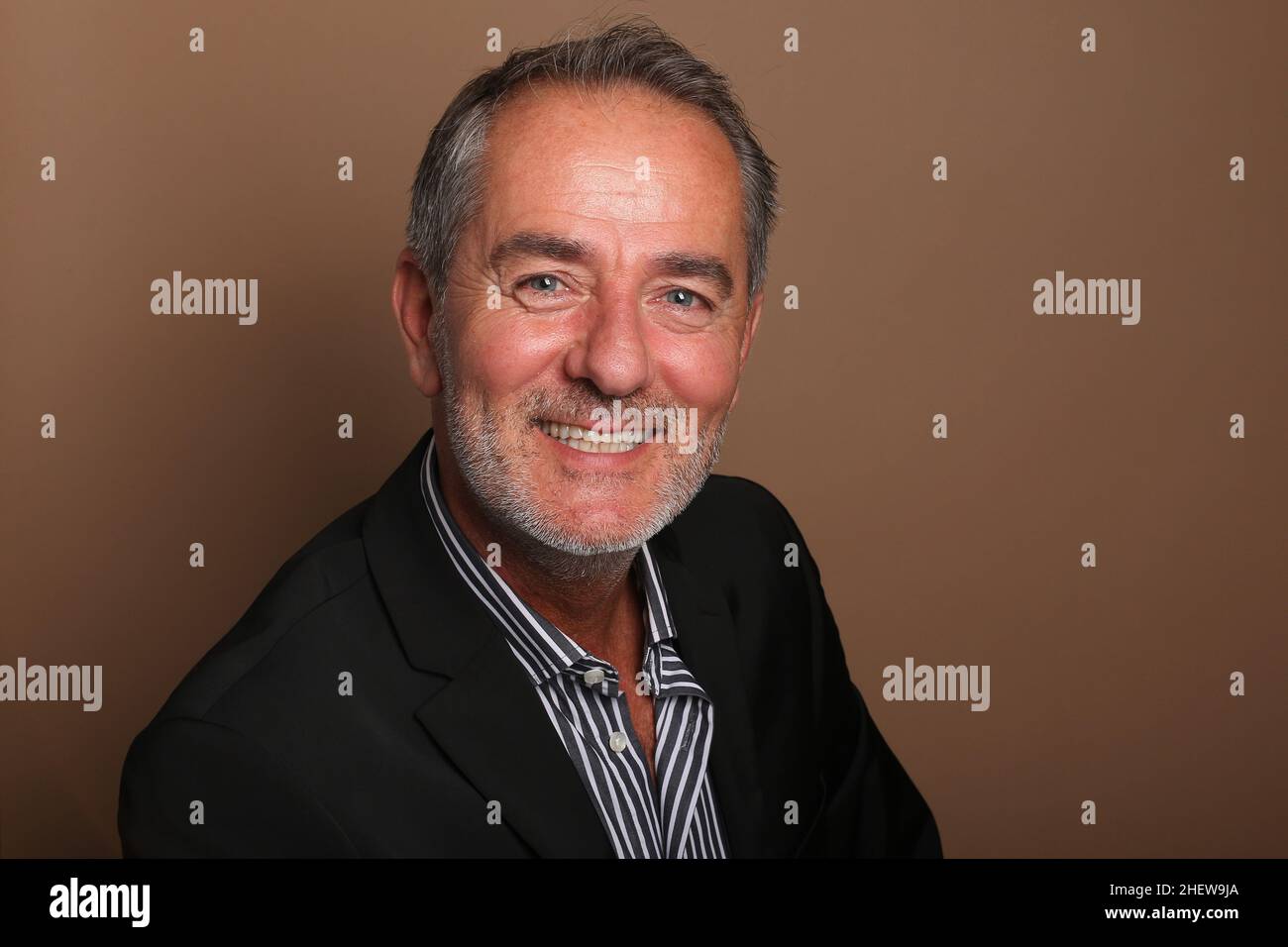 Portrait d'un bel homme heureux devant un arrière-plan coloré Banque D'Images