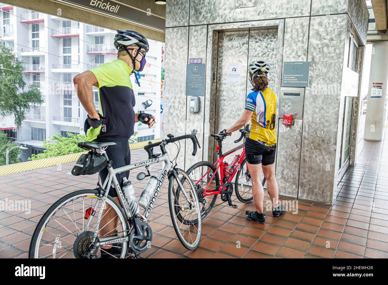 Miami Florida Brickell Metrorail train Station transport en commun plate-forme de transport ferroviaire homme femme couple motards cyclistes vélos attendant ascenseur Banque D'Images