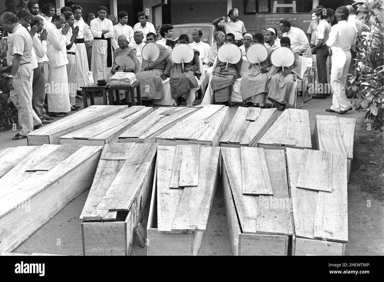 Les moines bouddhistes utilisent des ventilateurs de feuilles de palmier dans la chaleur lors d'un enterrement de masse pour des personnes tuées dans le bombardement de la gare routière centrale, le 27 avril 1987 à Colombo, Sri Lanka.Une énorme voiture piégée mise en place par les séparatistes tamouls a explosé à la gare routière centrale, tuant plus de 100 personnes et en blessant plus de 300. Banque D'Images