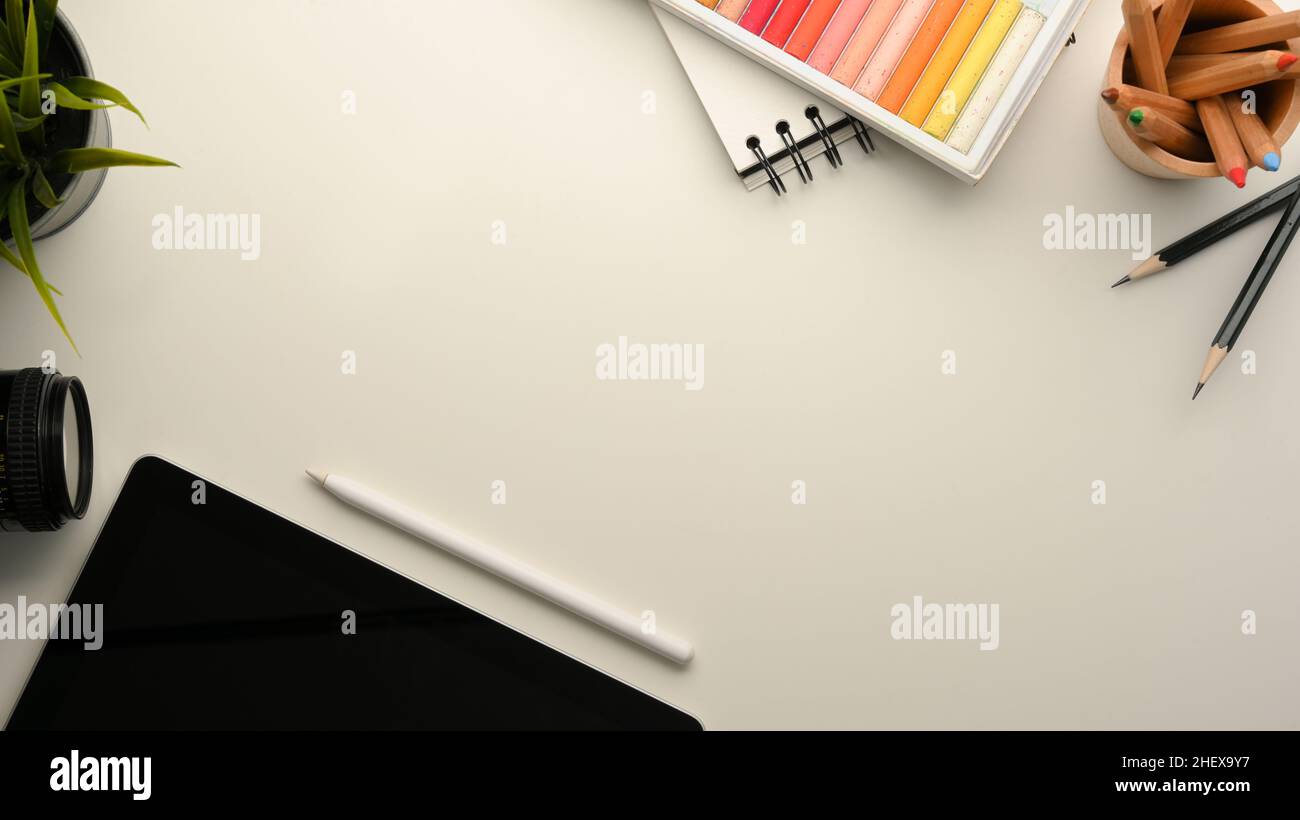 Espace de travail créatif avec tablette numérique, couleurs vives, papeterie et espace de copie sur fond blanc Banque D'Images