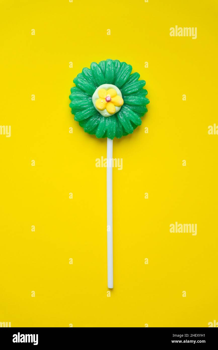 Lollipop en forme de fleur sur fond jaune.Vue du dessus de Lollipop Candy. Banque D'Images