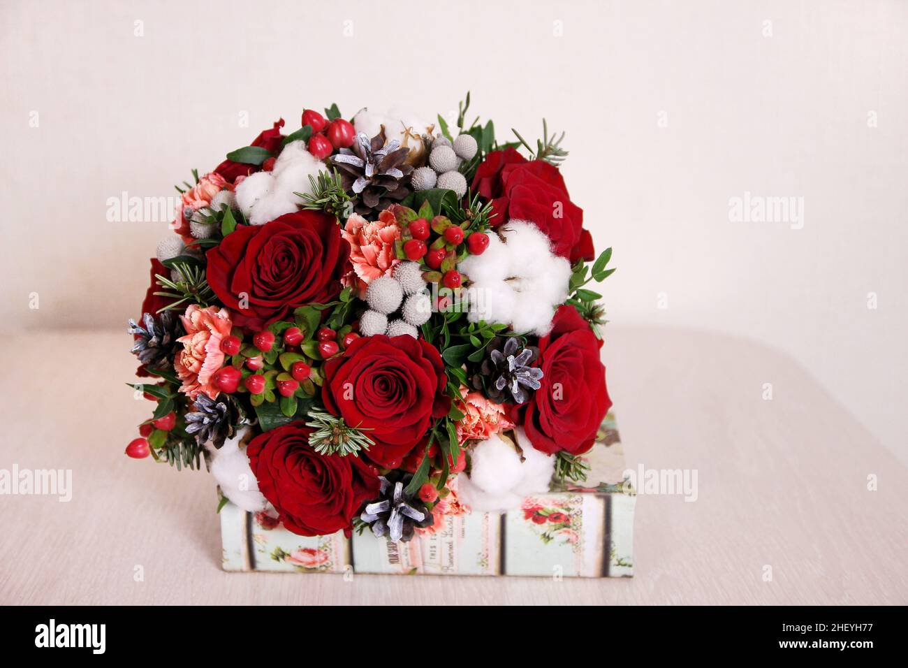 Bouquet rond rouge avec roses rouges, boules de coton, cônes, épinette et  autres fleurs.Bouquet de mariage d'hiver sur fond beige avec espace de  copie Photo Stock - Alamy