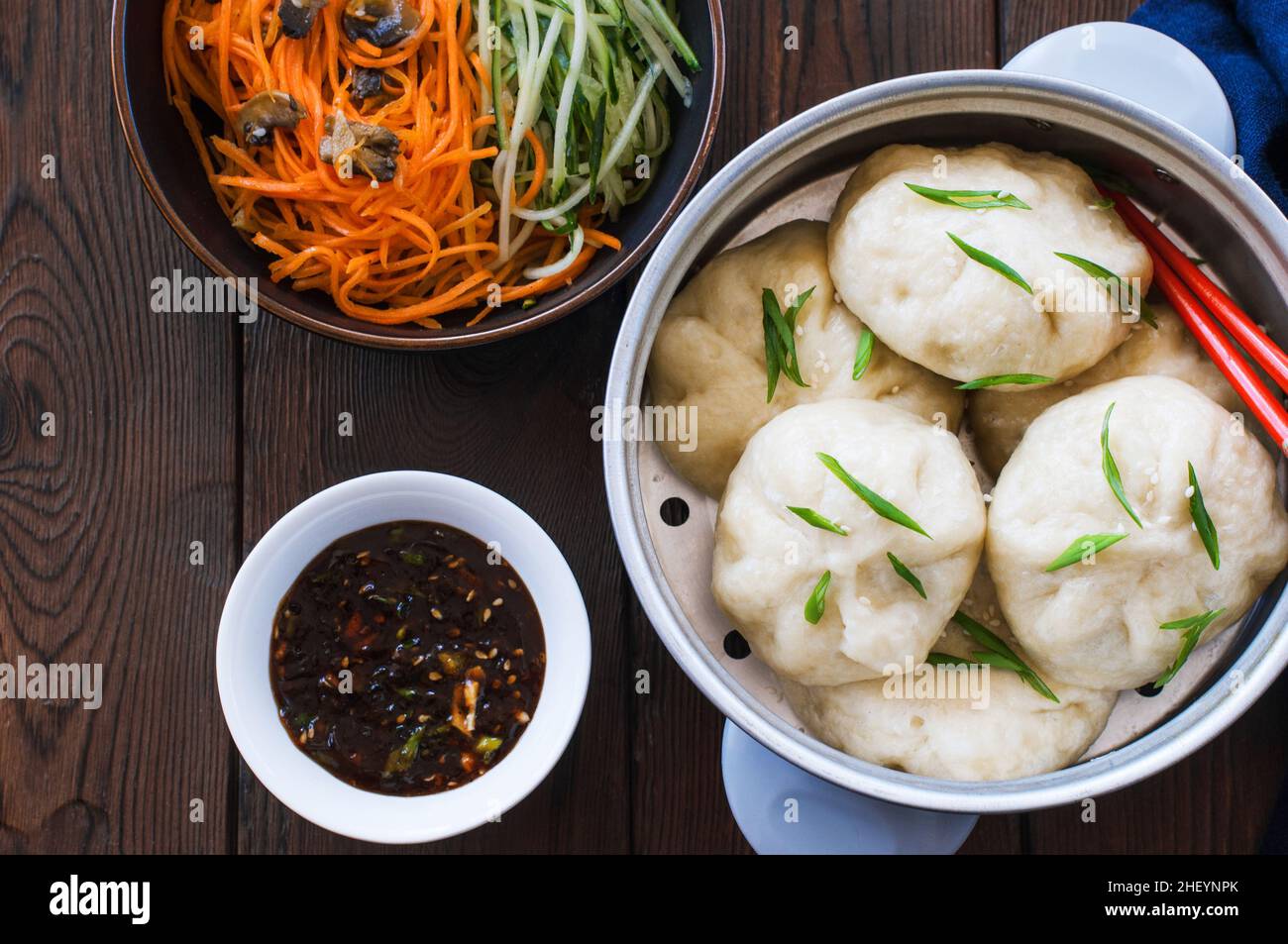 Petit pain chinois cuit à la vapeur avec garniture de viande servi avec des légumes frais et de la sauce soja.Gros plan. Banque D'Images