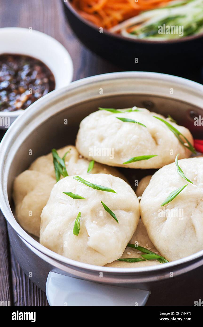 Petit pain chinois cuit à la vapeur avec garniture de viande servi avec des légumes frais et de la sauce soja.Gros plan. Banque D'Images