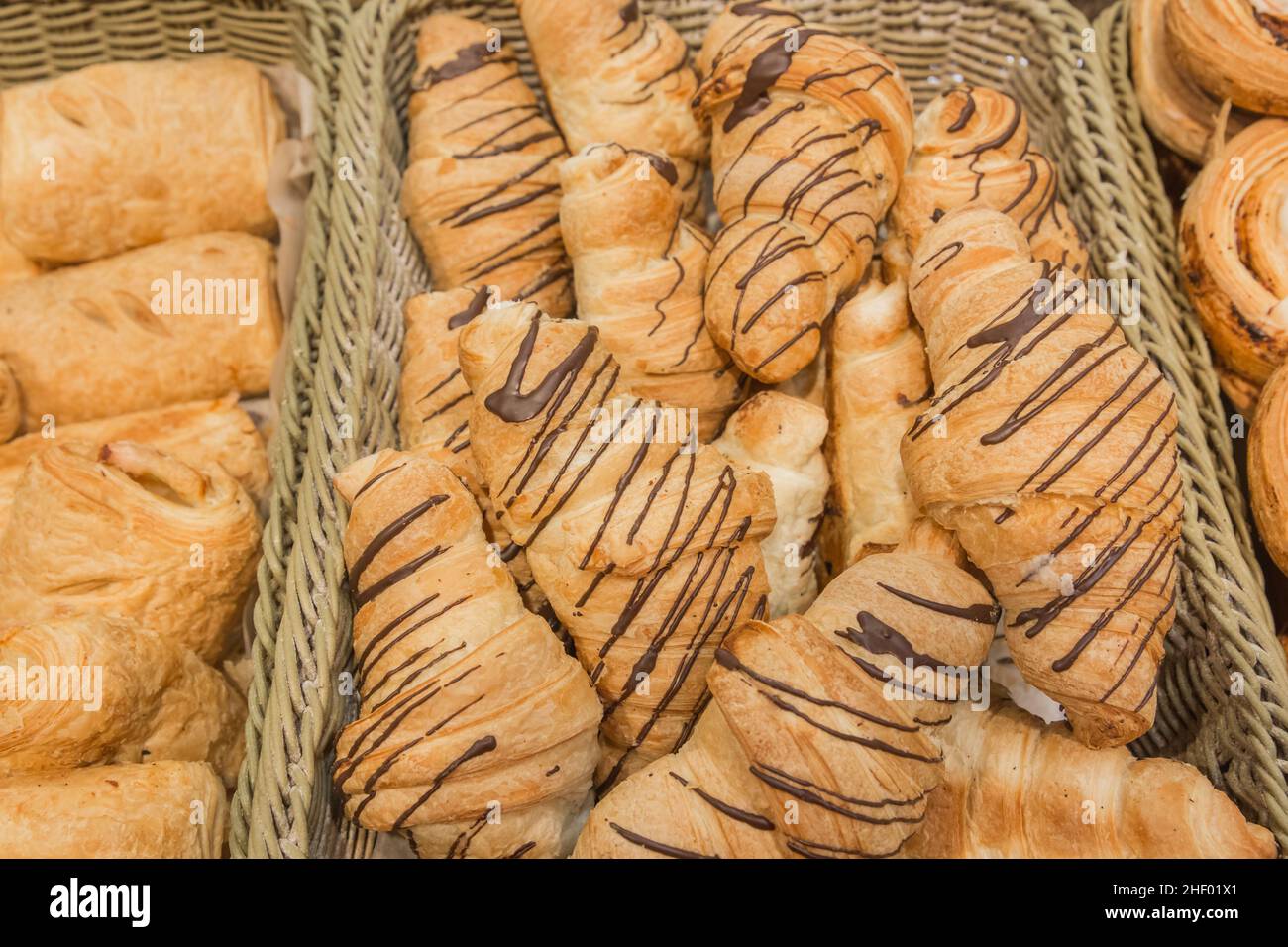 Croissants frais avec fond de chocolat et comptoir de boulangerie. Banque D'Images