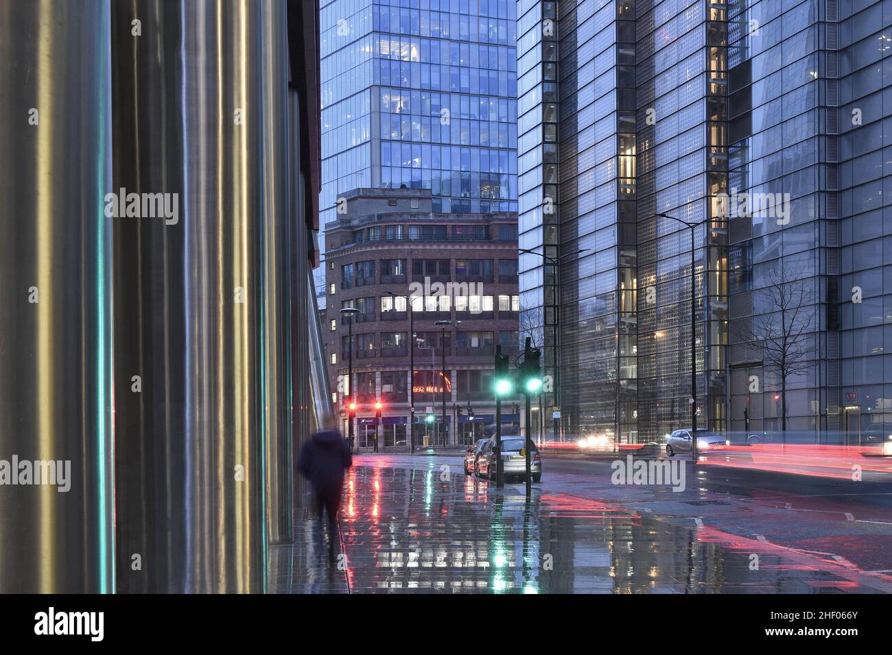 Propriétés modernes avec bâtiment en verre de la tour Heron, rue pluvieuse au crépuscule dans la ville de Londres Royaume-Uni. Banque D'Images