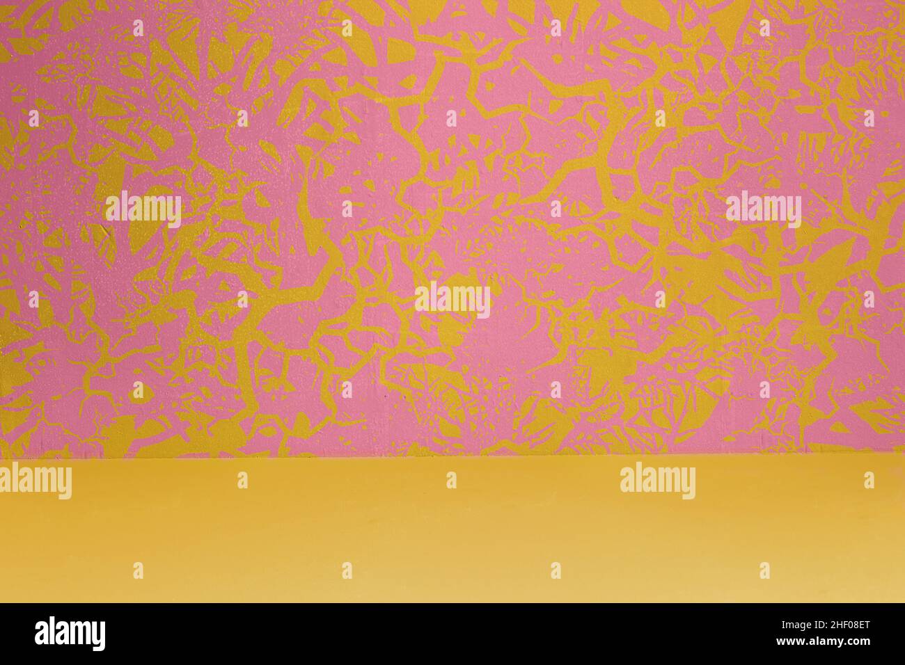 Mur d'art décoré de peintures formant des formes abstraites dynamiques sur fond pastel et sol jaune.Motifs originaux avec bac à texture Banque D'Images