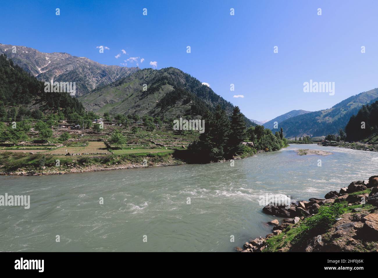 Fast River et Green Mountain Forest sous le ciel bleu dans les Highlands de Gilgit, au Pakistan Banque D'Images
