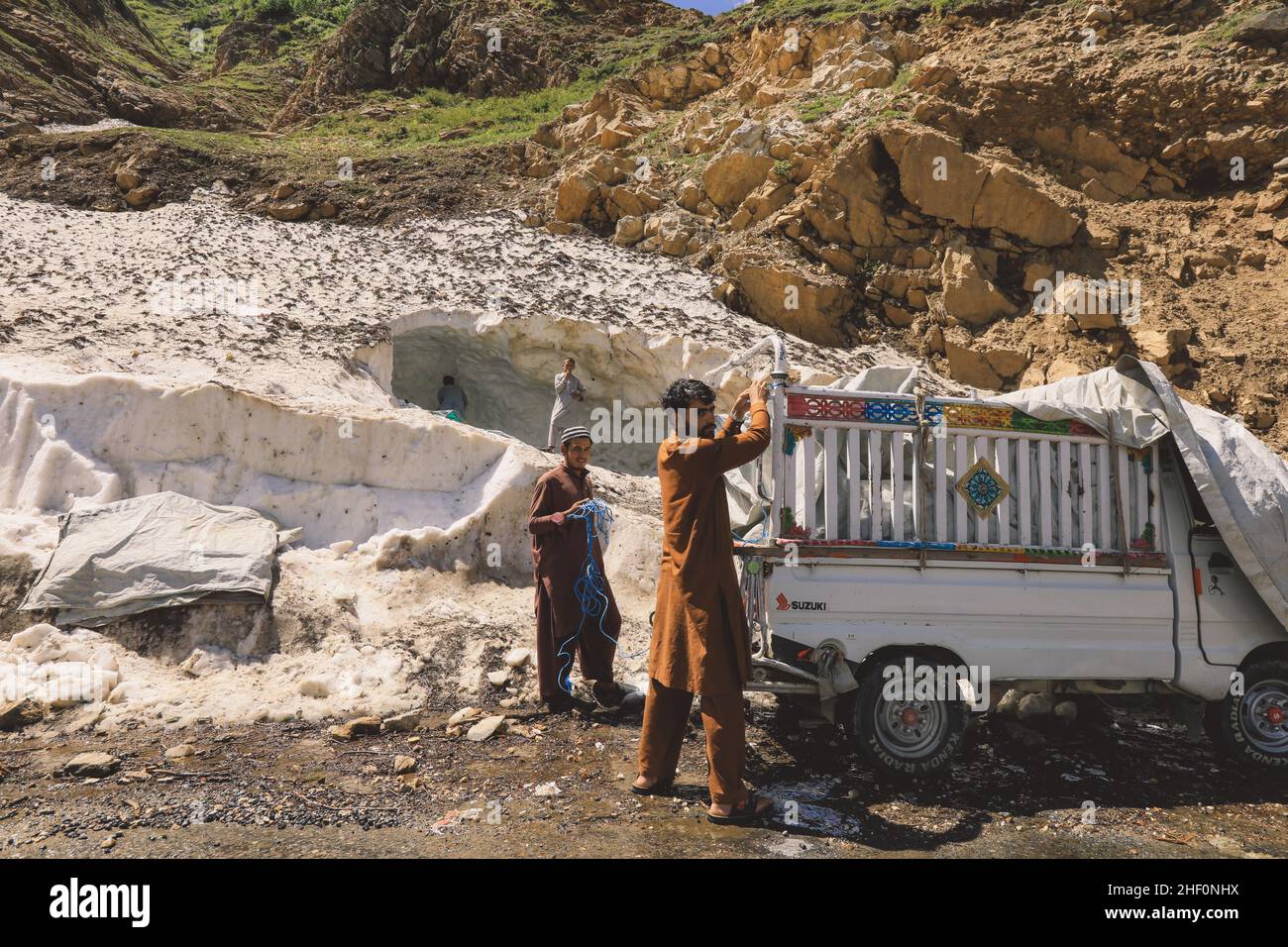 Gilgit, Pakistan - 08 juin 2018 : les Pakistanais ramassez la neige et chargent la voiture dans les montagnes Banque D'Images