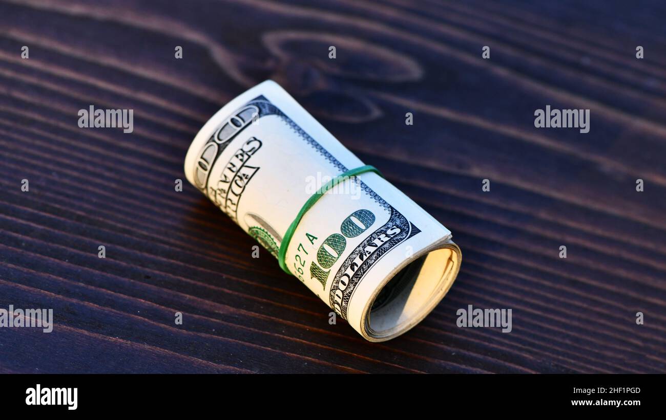 Rouleau de mille dollars 1000 dollar dans des billets de cent dollars isolés sur fond de bois Banque D'Images Rouleau de mille dollars 1000 dollar dans des billets de cent dollars isolés sur fond de bois Banque D'Images