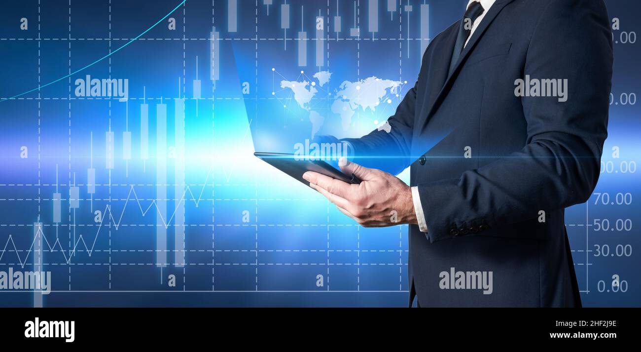 Homme d'affaires tenant une tablette et examinant les données économiques mondiales.Investisseurs et courtiers en actions qui examinent les actions Banque D'Images
