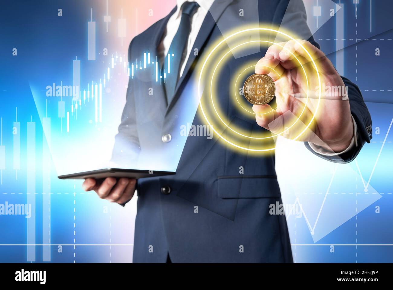 Homme d'affaires tenant une tablette avec des données de crypto-monnaie en hausse tout en montrant une pièce de monnaie en bitcoin avec sa main.Investir dans des devises virtuelles Banque D'Images