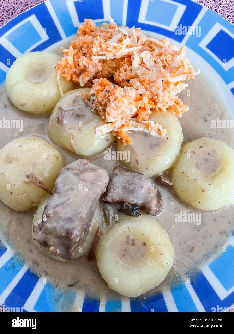 Des boulettes de levure polonaises cuites à la vapeur ou de la kluski na peuvent être servies avec de la viande et de la sauce ou sautées dans du beurre et saupoudrées de sucre pour le dessert. Banque D'Images