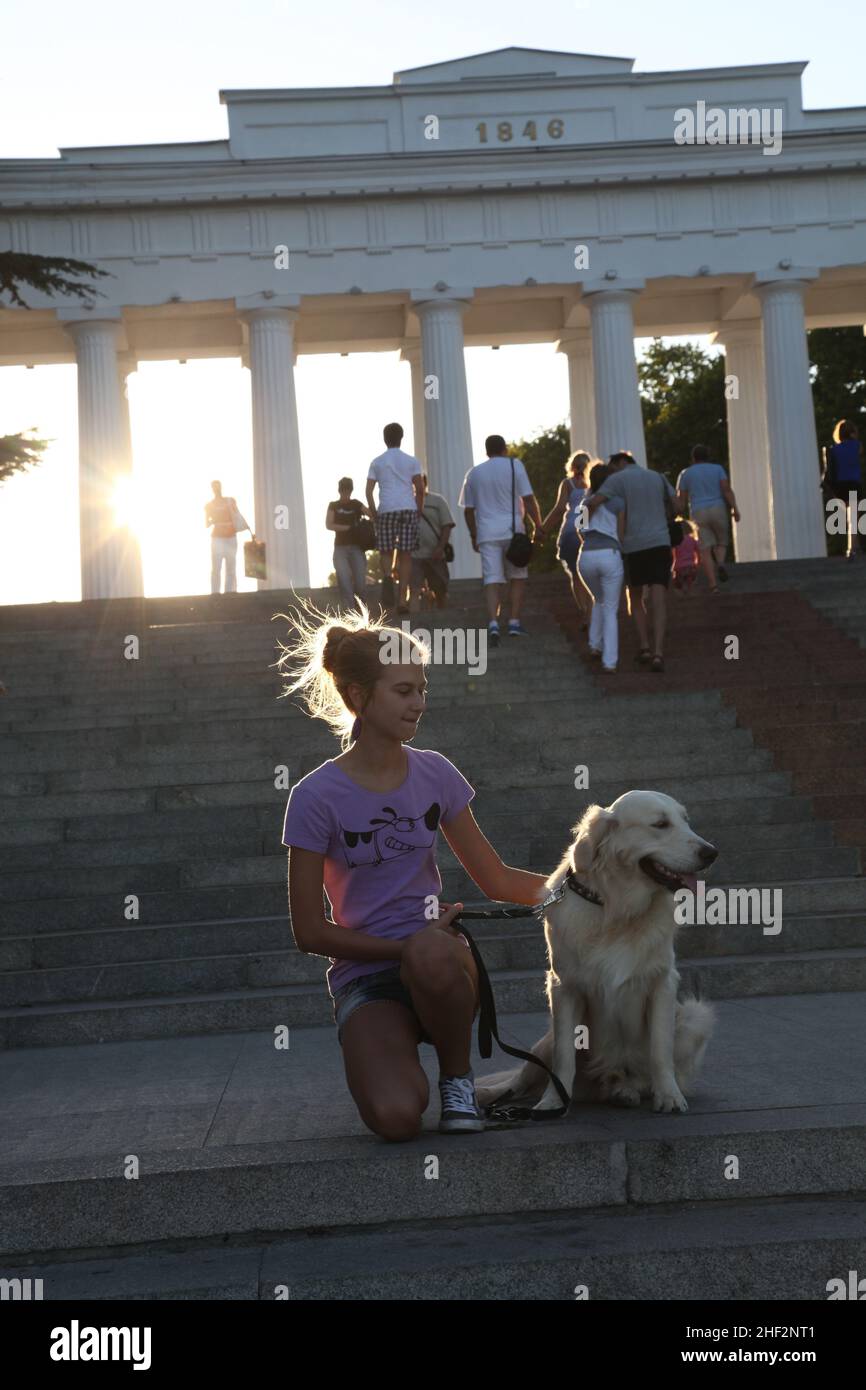 Une jeune fille russe apprécie son séjour à Sébastopol, la ville des marins russes de Crimée à Grafskaya Pristan port Steps avec son chien Golden Retriever Banque D'Images
