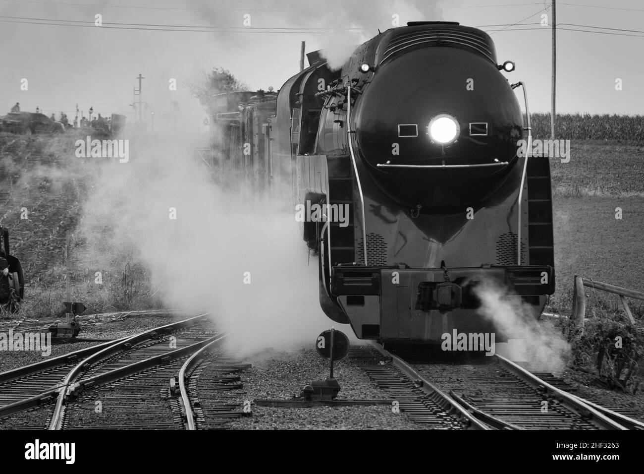 Noir et blanc d'un train de fret à vapeur restauré antique approchant la tête sur la fumée et la vapeur soufflantes Banque D'Images