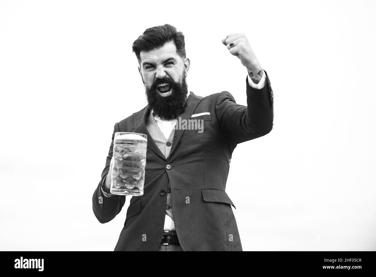 Drôle d'homme en costume classique tenant le verre avec la bière à la main. Homme excité avec de la bière. Brasseur barman avec des émotions d'expression. Banque D'Images