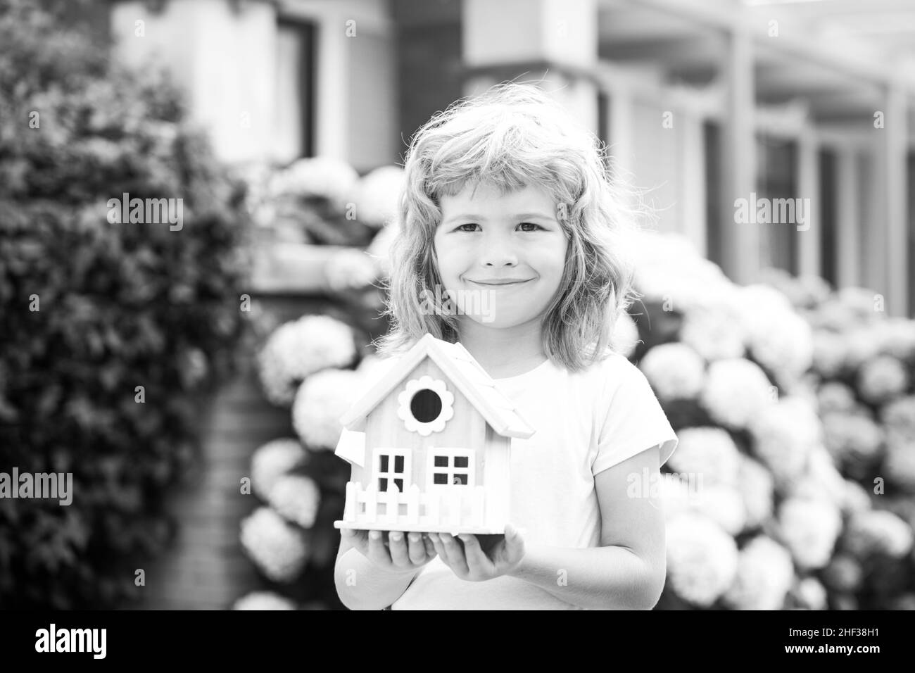 Enfant garçon avec petit jouet maison en bois, nouveau concept de maison. Banque D'Images