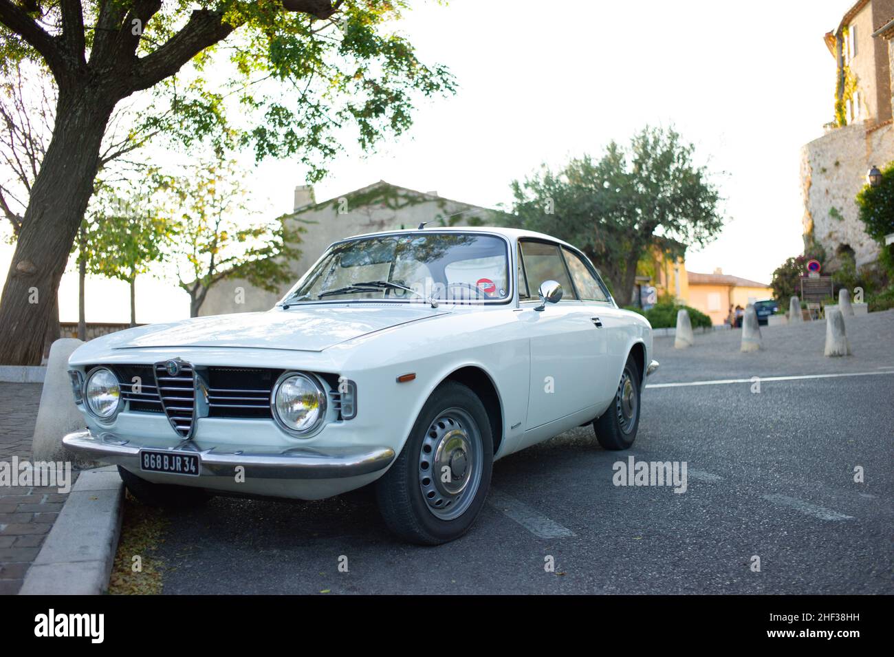 Un blanc 1600 Giulia Sprint GT Veloce garé dans la rue dans le pittoresque village français perché du Castellet. Banque D'Images