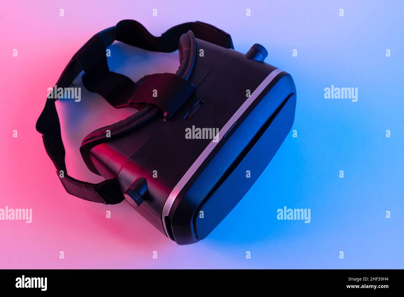 Masque de lunettes VR noires sur fond de couleur néon.Casque de réalité virtuelle Banque D'Images