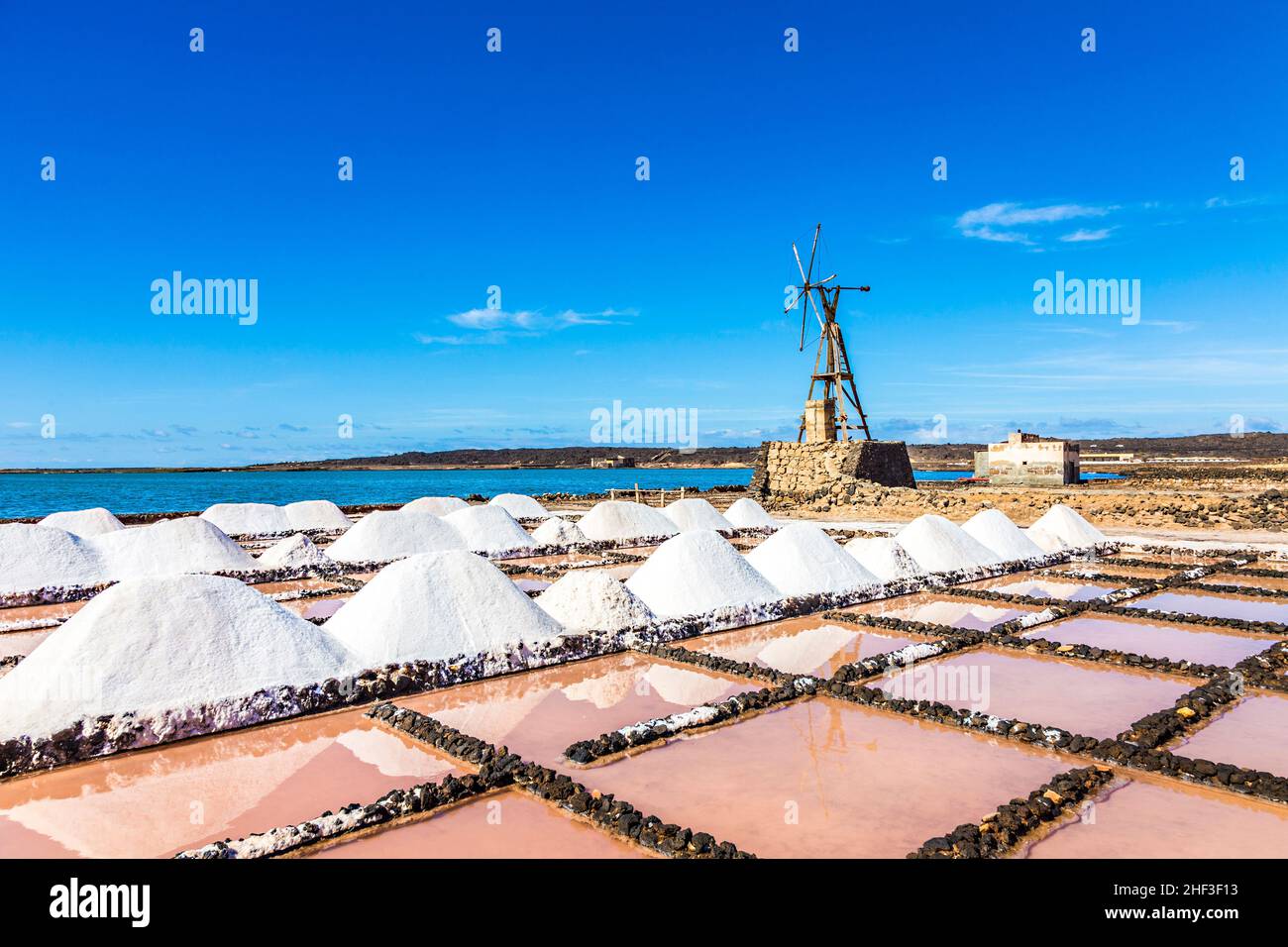 Dans l'amas de sels de salines de Janubio à Lanzarote avec l'ancien moulin à vent toteen sous ciel bleu Banque D'Images