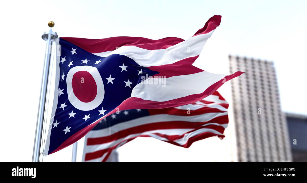 Le drapeau de l'État américain de l'Ohio agité dans le vent avec le drapeau américain flou dans le fond.Le drapeau de l'État de l'Ohio est le seul drapeau non rectangulaire Banque D'Images