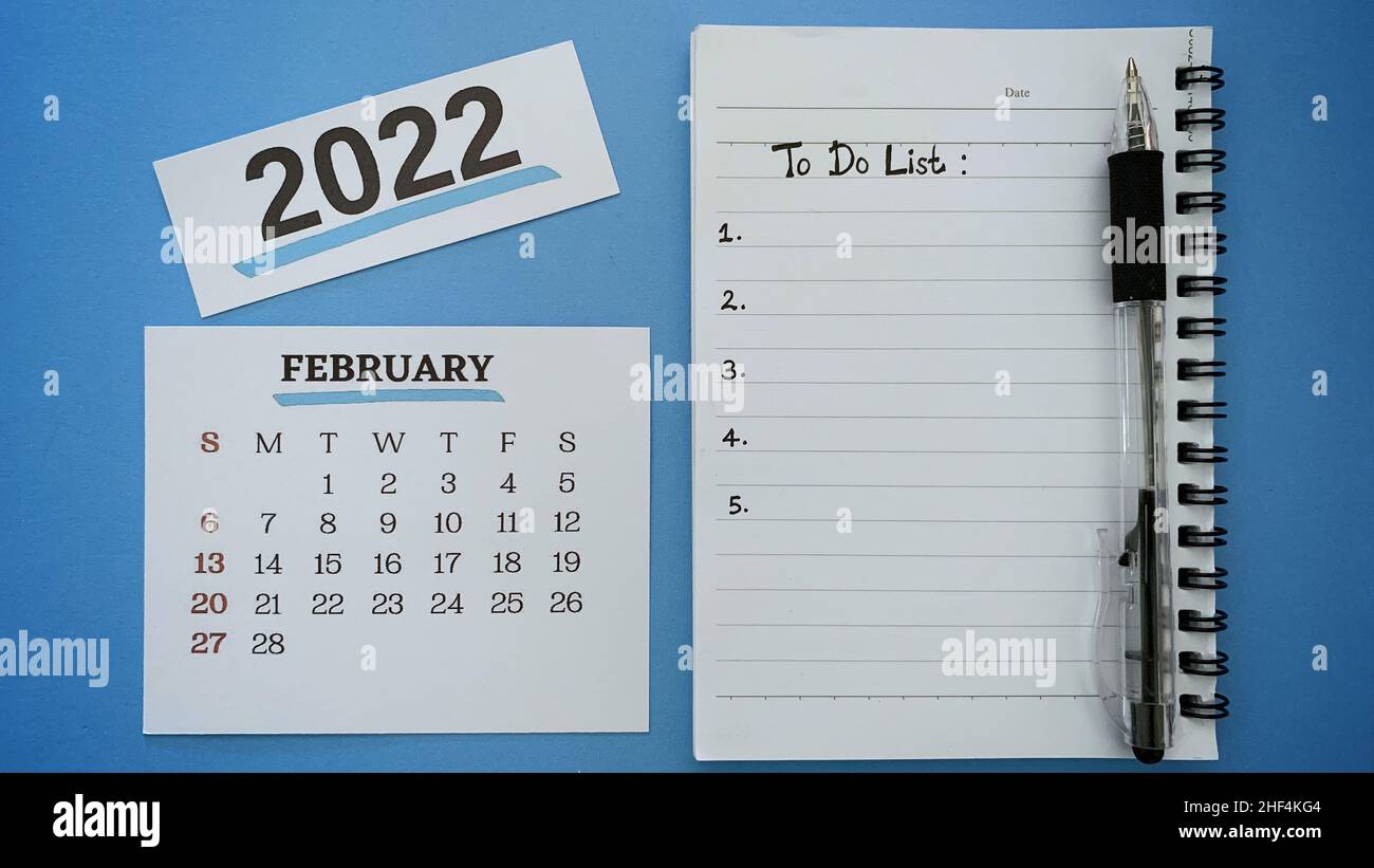 Texte de liste des tâches écrit à la main sur le bloc-notes pour le mois de février 2022.Avec stylo et fond bleu.concept de la nouvelle année 2022. Banque D'Images