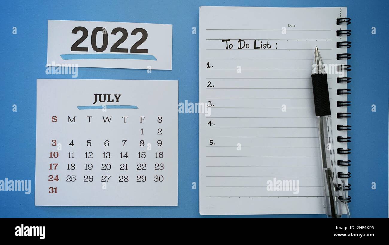 Liste des tâches sur le livre de notes avec stylo et fond du mois 2022 du calendrier de juillet.concept de la nouvelle année 2022. Banque D'Images