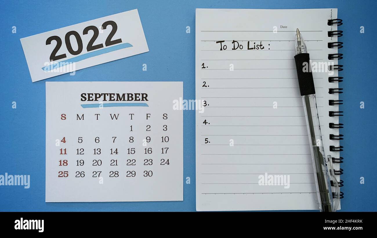 Texte de liste des tâches écrit à la main sur le bloc-notes du mois de septembre avec un stylo et un arrière-plan bleu.concept de la nouvelle année 2022. Banque D'Images