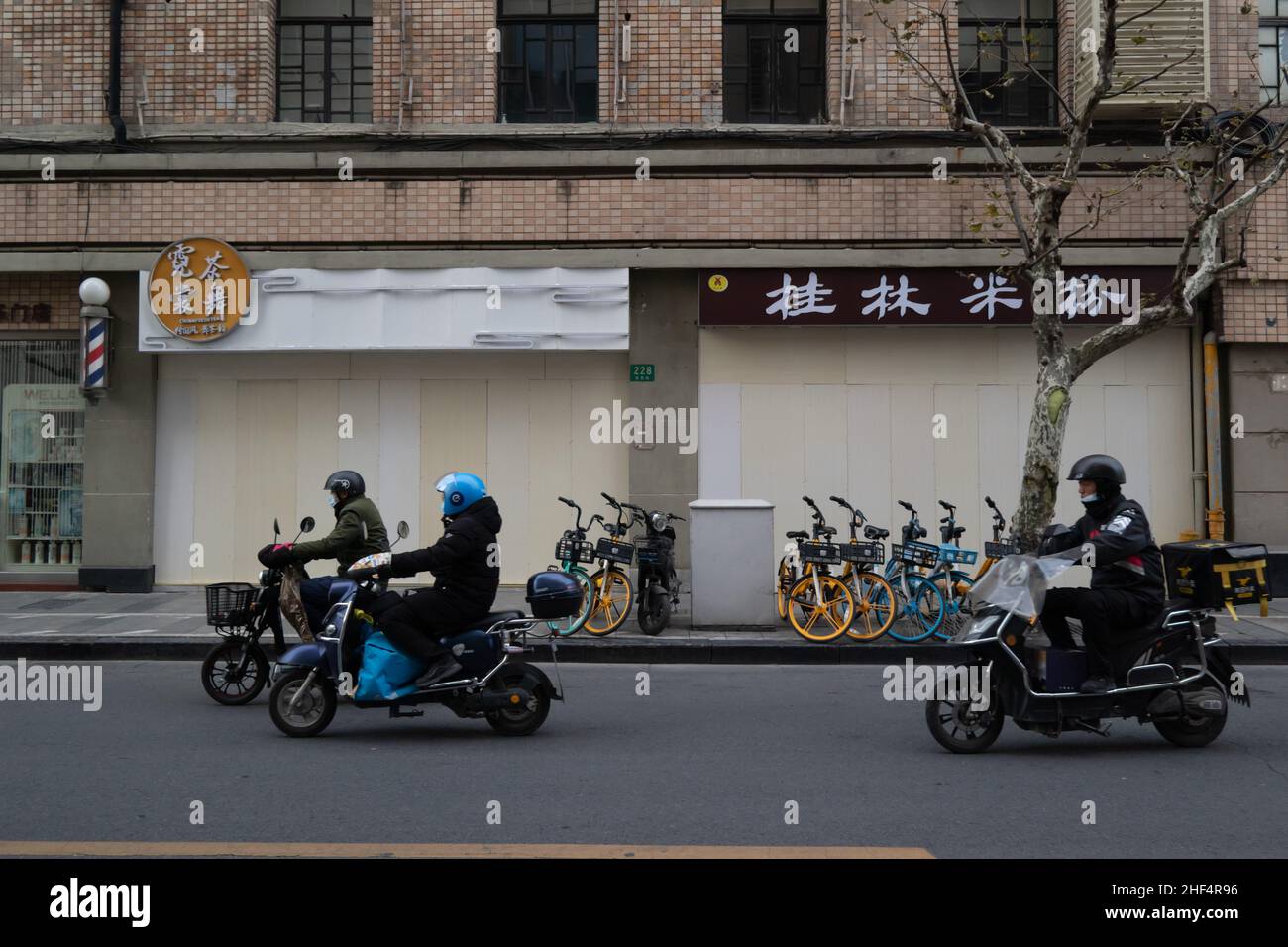 Deux magasins le long de la rue au 228 Yuyuan Road, classé comme zone à risque moyen, ont été fermés avec des barrières de couleur claire, et les routes environnantes a Banque D'Images