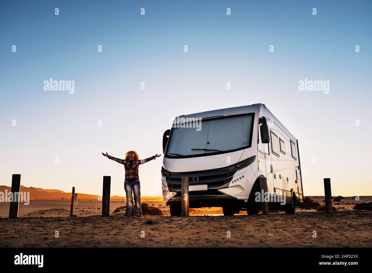 Femme debout devant les bras et profitant de la liberté et du style de vie de voyage avec la camionnette moderne de camping-car.Autre mode de vie à la maison et en voyage pour Happy pe Banque D'Images